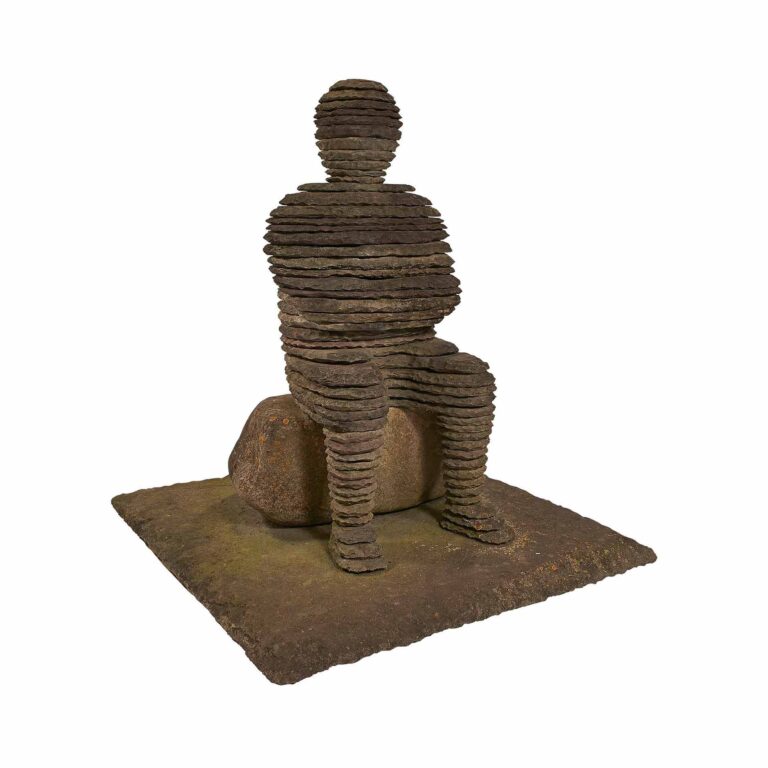 rock sculpture of a figure sitting