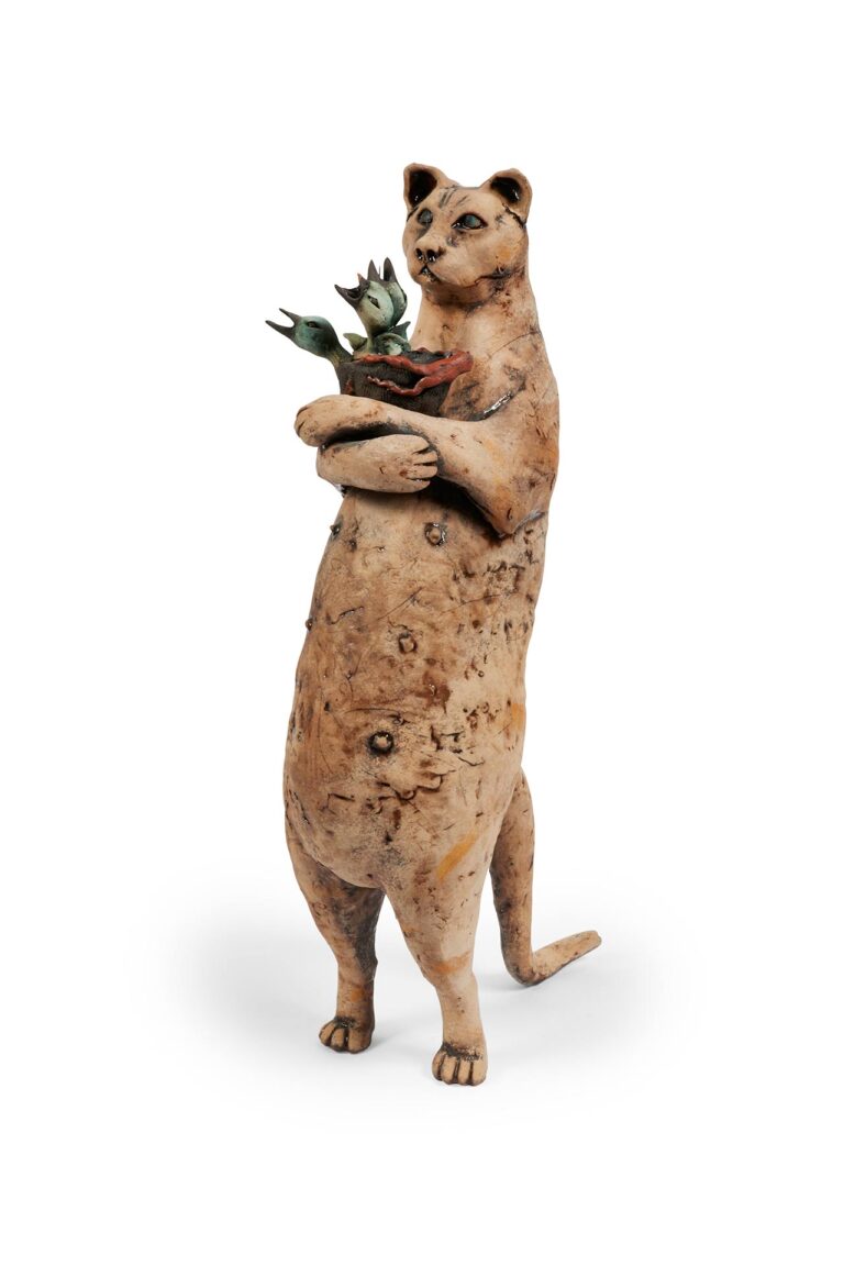 A sculpture of a cat holding baby birds.
