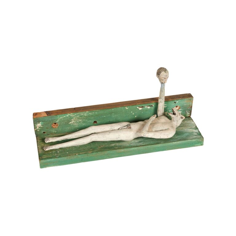 A ceramic sculpture of a figure laying down.