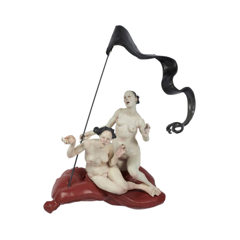 A ceramic sculpture of two naked woman with a flag.