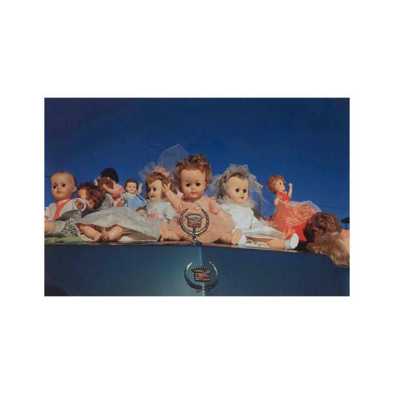 A picture of dolls on a Cadillac.