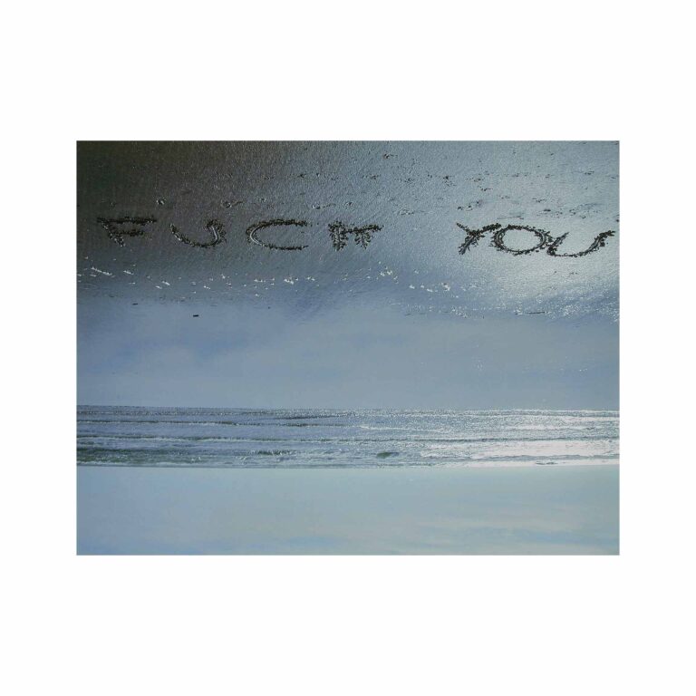 A photograph of the ocean and a message in the sand.