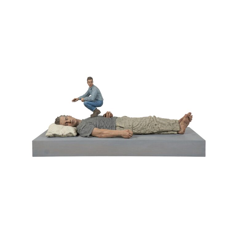 A sculpture of a small man standing on top of a larger sleeping man.