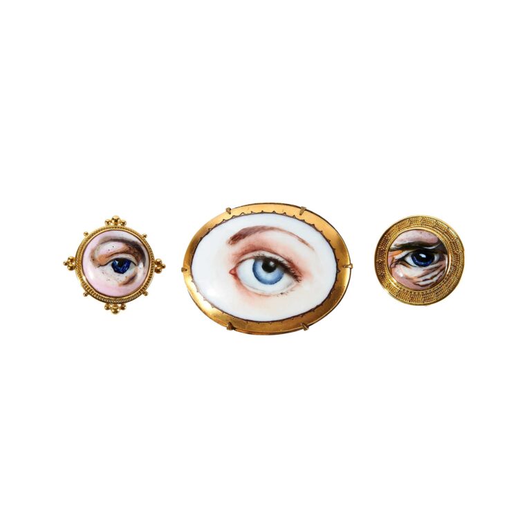 Three brooches with eyes on them.