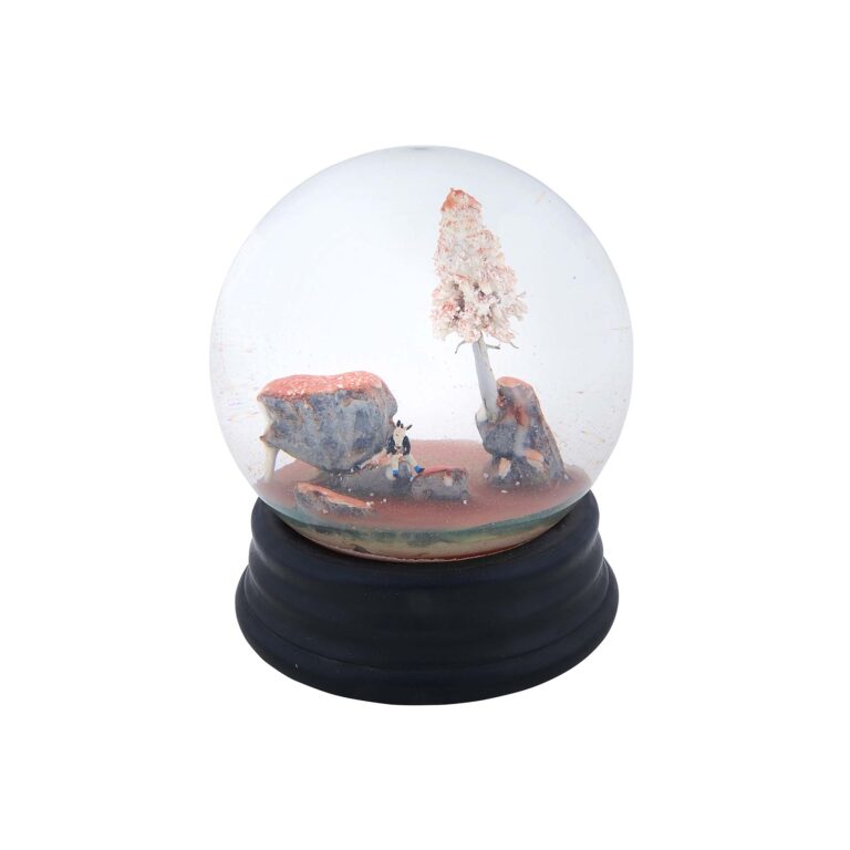 A sculpture resembling a snow globe with a figure inside.