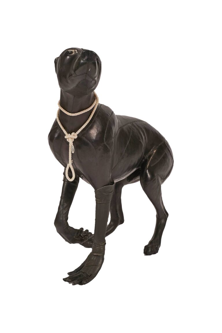 A sculpture of a dog with a noose of pearls around its neck.