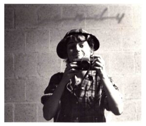 A person holding up a camera and smiling.